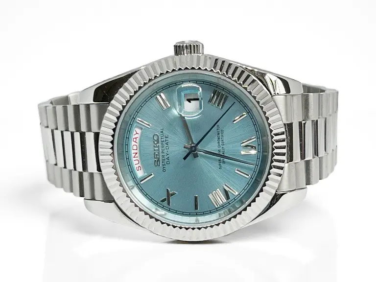 Seiko Mod Day‑Date Ice‑Blue – elegante Frontansicht mit eisblauem Sunburst-Zifferblatt Seiko Mod Day-Date Ice‑Blue – Frontansicht auf weißem Hintergrund