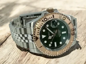 Seiko Mod Yacht‑Master aus leicht schräger Perspektive: smaragdgrünes Zifferblatt, roségoldene Lünette, geöffnete Jubilee‑Schließe auf rustikalem Holz
