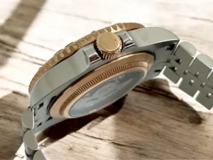 Detailaufnahme der Gehäuseseite: verschraubte roségoldene Krone, geriffelte Lünette und transparenter Sichtboden des Seiko Mod Yacht‑Master