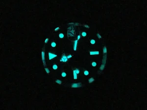BGW9‑Leuchtbild des Seiko Mod Yacht‑Master im Dunkeln: Zeiger und Indizes strahlen blau