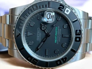 Detailaufnahme des Zifferblatts der Seiko Mod Yacht-Master Stealth mit Mercedes-Zeigern